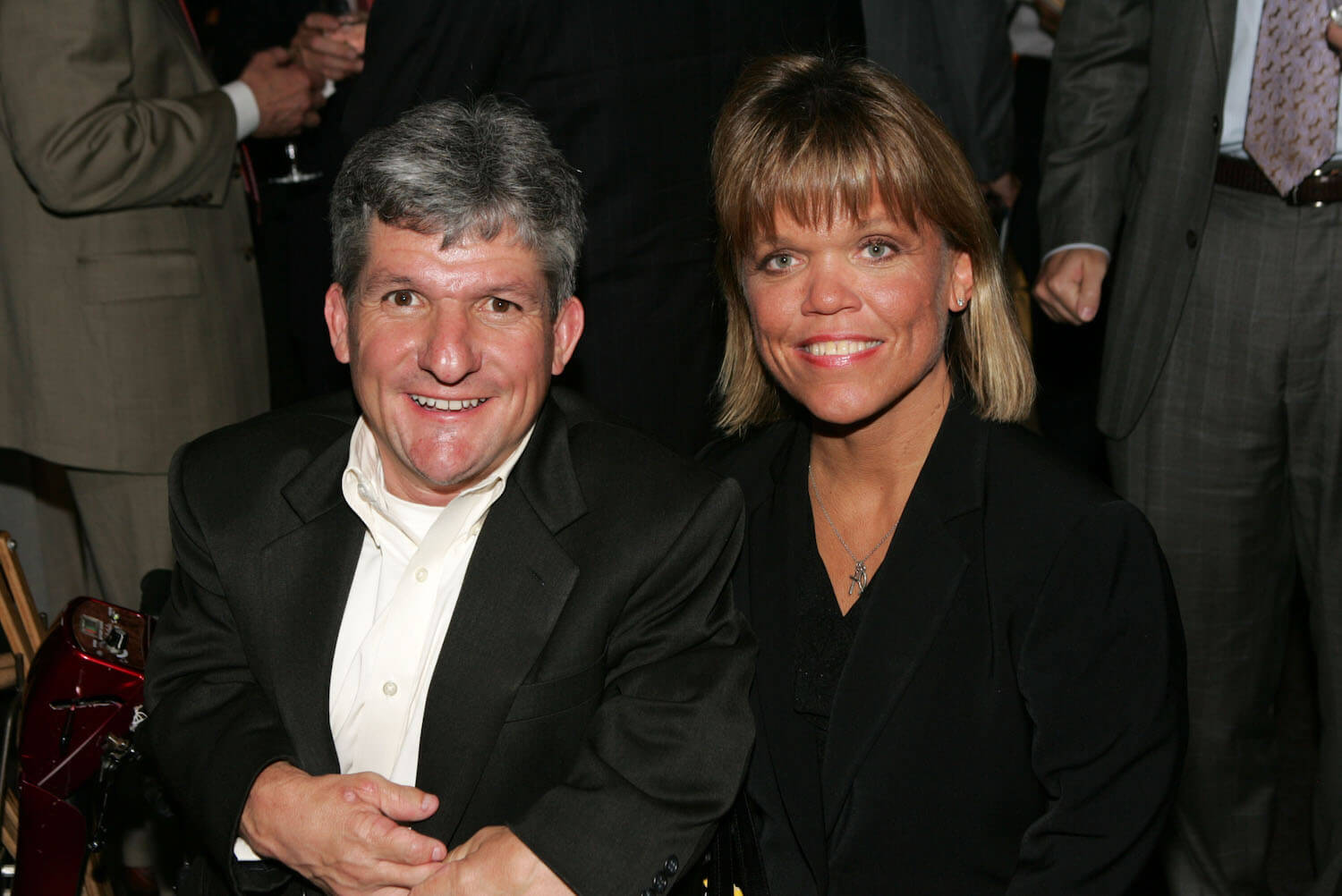 Matt Roloff and Amy Roloff from 'Little People, Big World' sitting next to each other and smiling against a black background