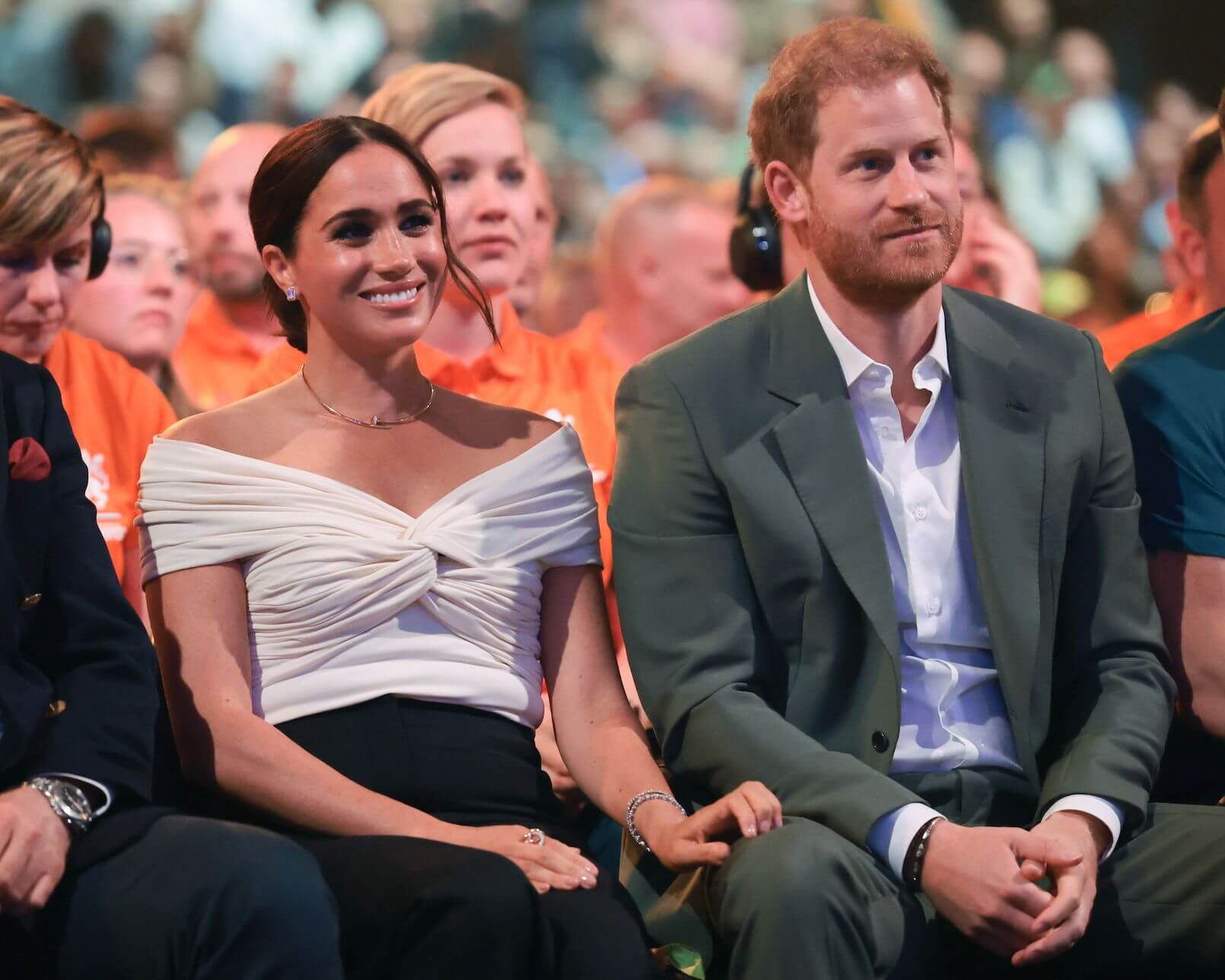 Meghan Markle and Prince Harry sitting next to each other. Meghan isn't attending King Charles' coronation.
