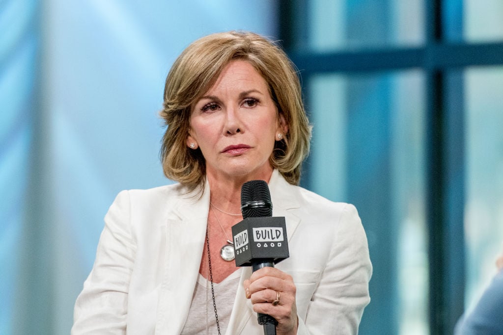 Melissa Gilbert sits, holding a microphone.