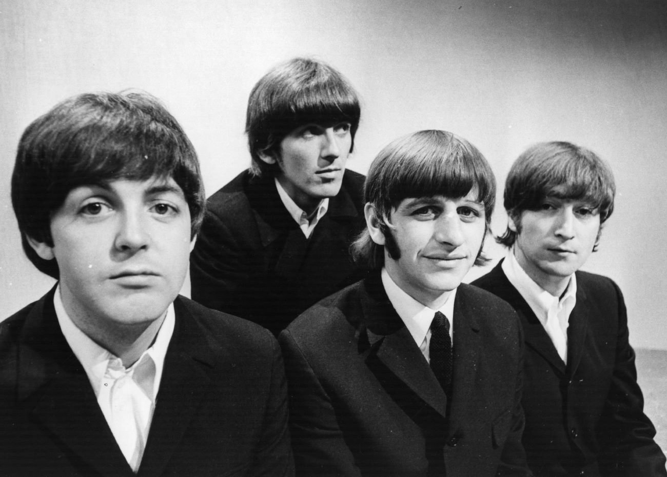 A black and white picture of Paul McCartney, George Harrison, Ringo Starr, and John Lennon of The Beatles wearing black jackets.