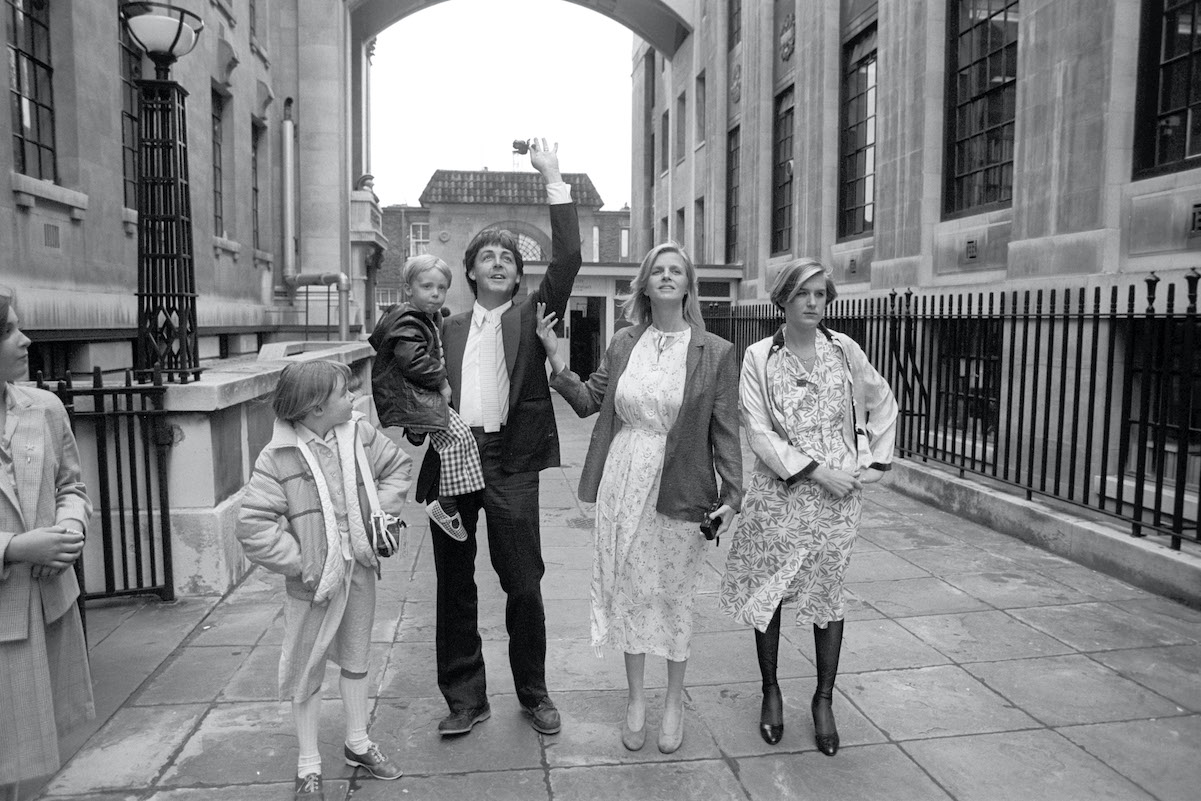 Paul McCartney waves to fans while with his four children in 1981