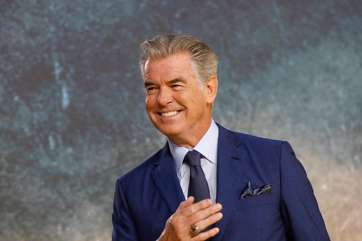 Pierce Brosnan smiling while taking a picture at the 'Black Adam' premiere.