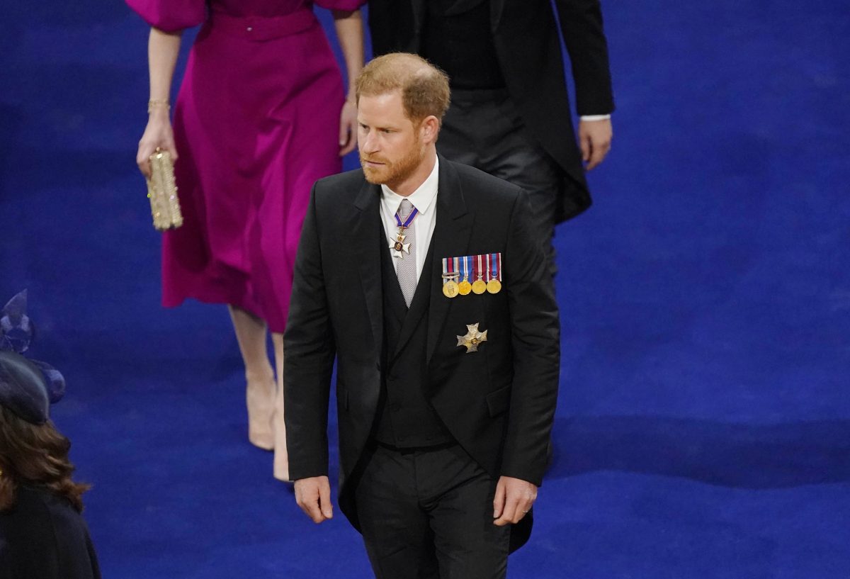 Prince Harry walking to his seat before the coronation at Westminster Abbey
