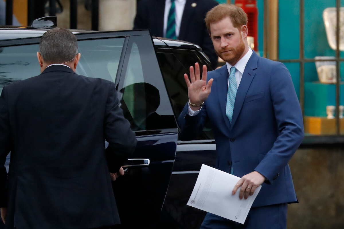 Prince Harry, who will reportedly have an emotionally difficult time at the coronation, waves as he gets in a car outside Westminster Abbey