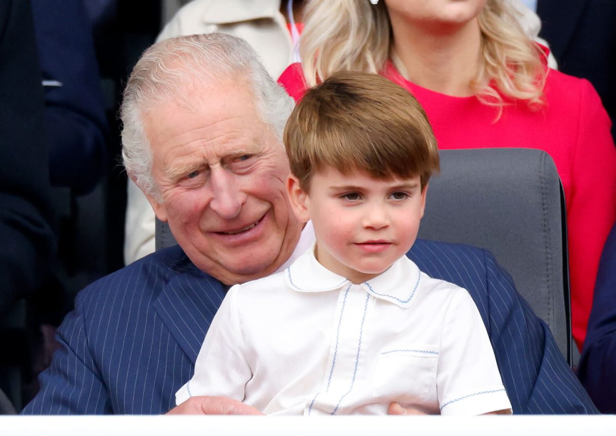 Prince Louis sits on his grandfather King Charles' lap as they watch the Platinum Pageant