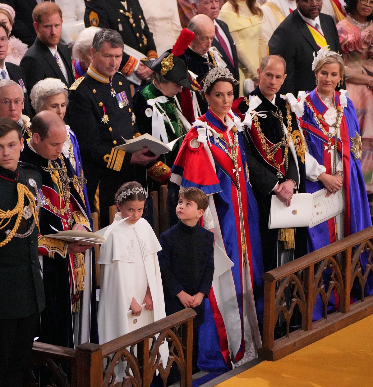Prince William, Prince Harry, and other members of the royal family standing inside Westminster Abbey for King Charles III's coronation