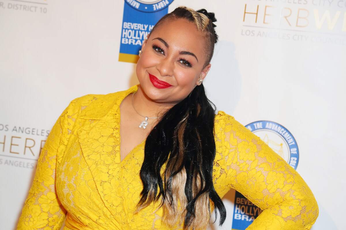 Raven Symone posing in a yellow dress