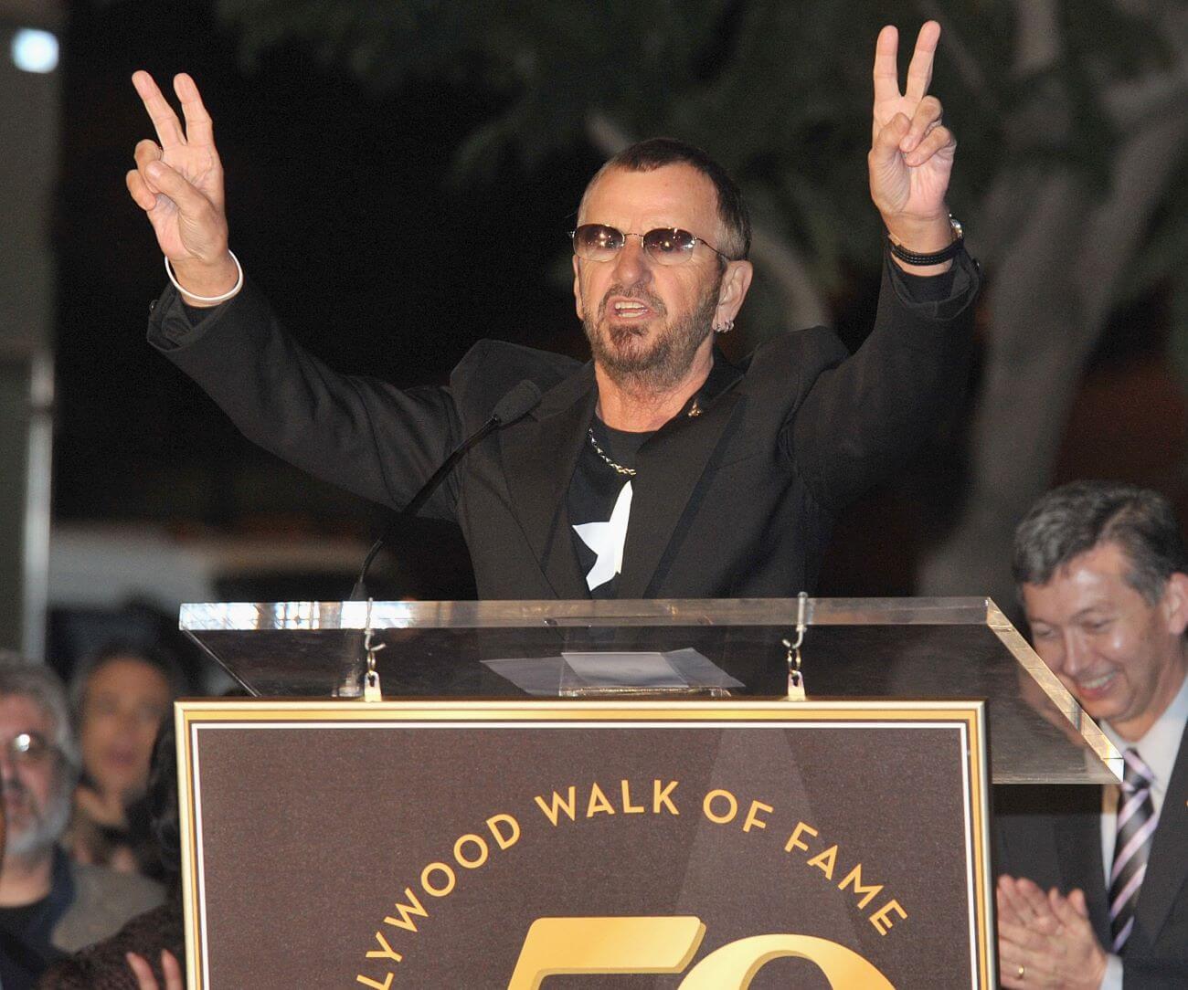 Ringo Starr holds up two peace signs at the Hollywood Walk of Fame