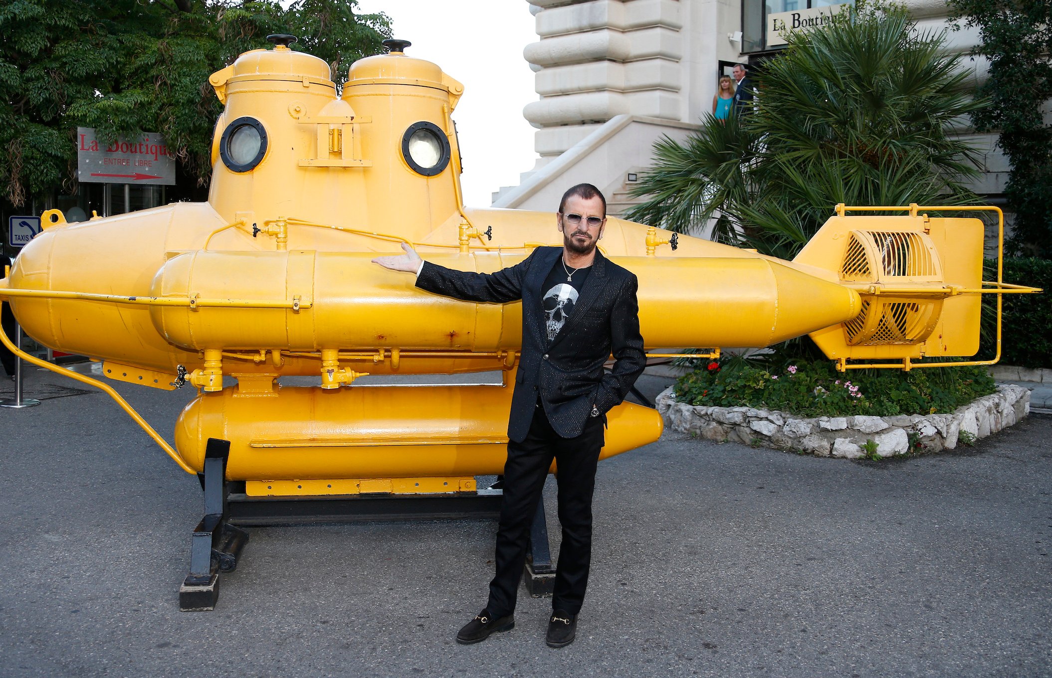 Ringo Starr poses in front of a yellow submarine at the Oceanographic Museum in Monaco