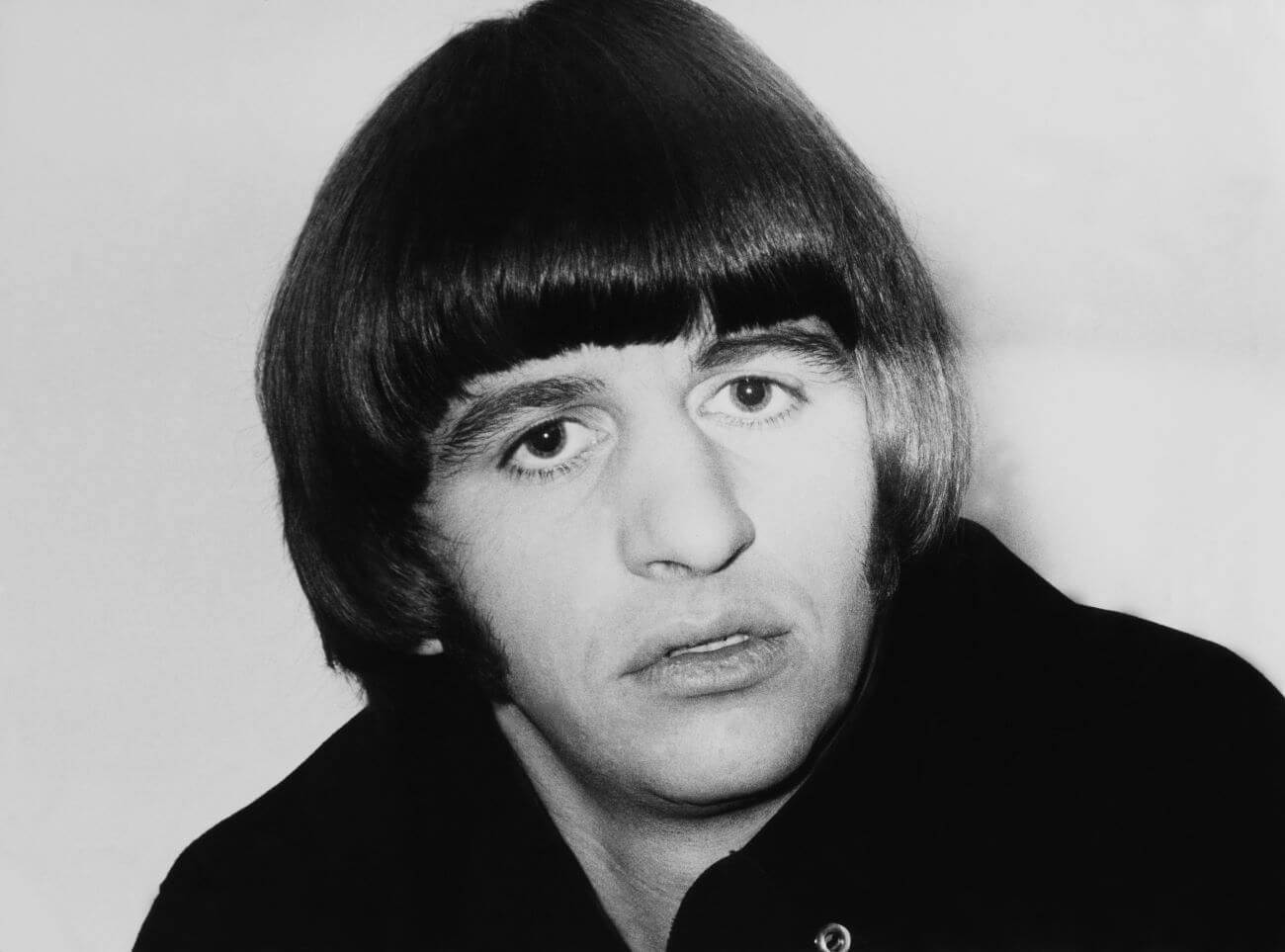 Una foto en blanco y negro de Ringo Starr de The Beatles con un abrigo.