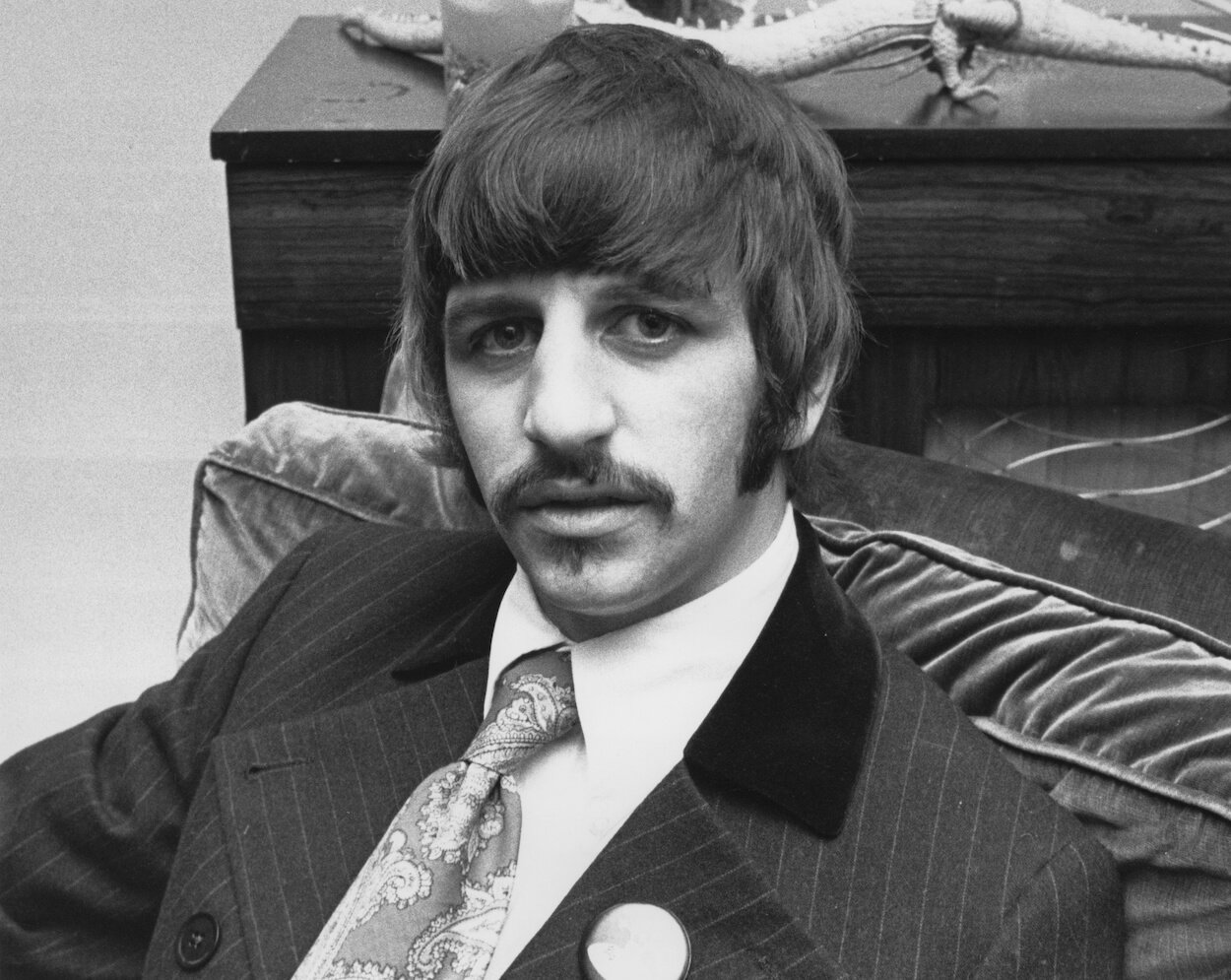 Beatles drummer Ringo Starr wearing a pinstriped suit and sporting a mustache while sitting in an easy chair in 1967.