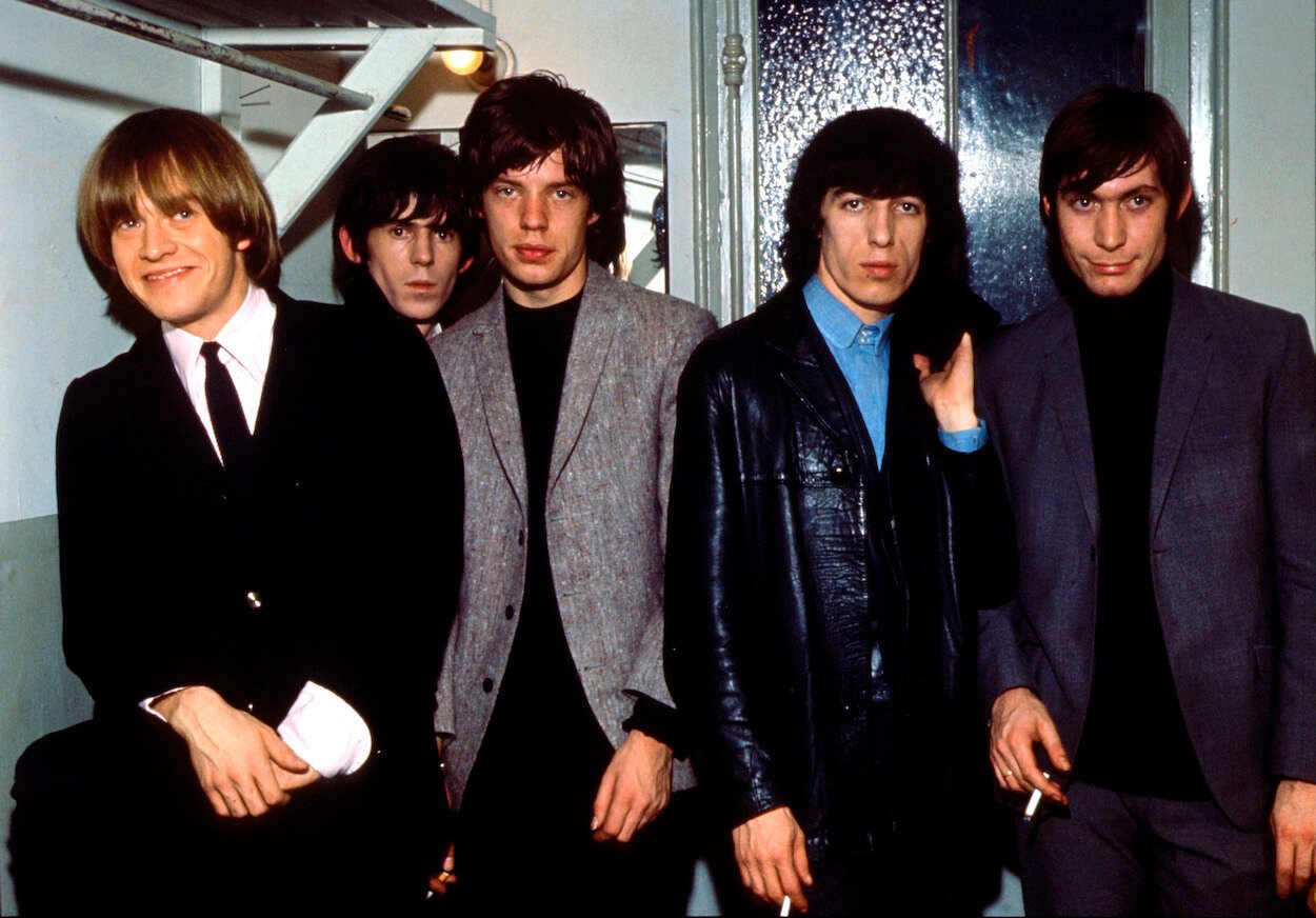 Rolling Stones members (from left) Brian Jones, Keith Richards, Mick Jagger, Bill Wyman, and Charlie Watts standing in a dressing room.