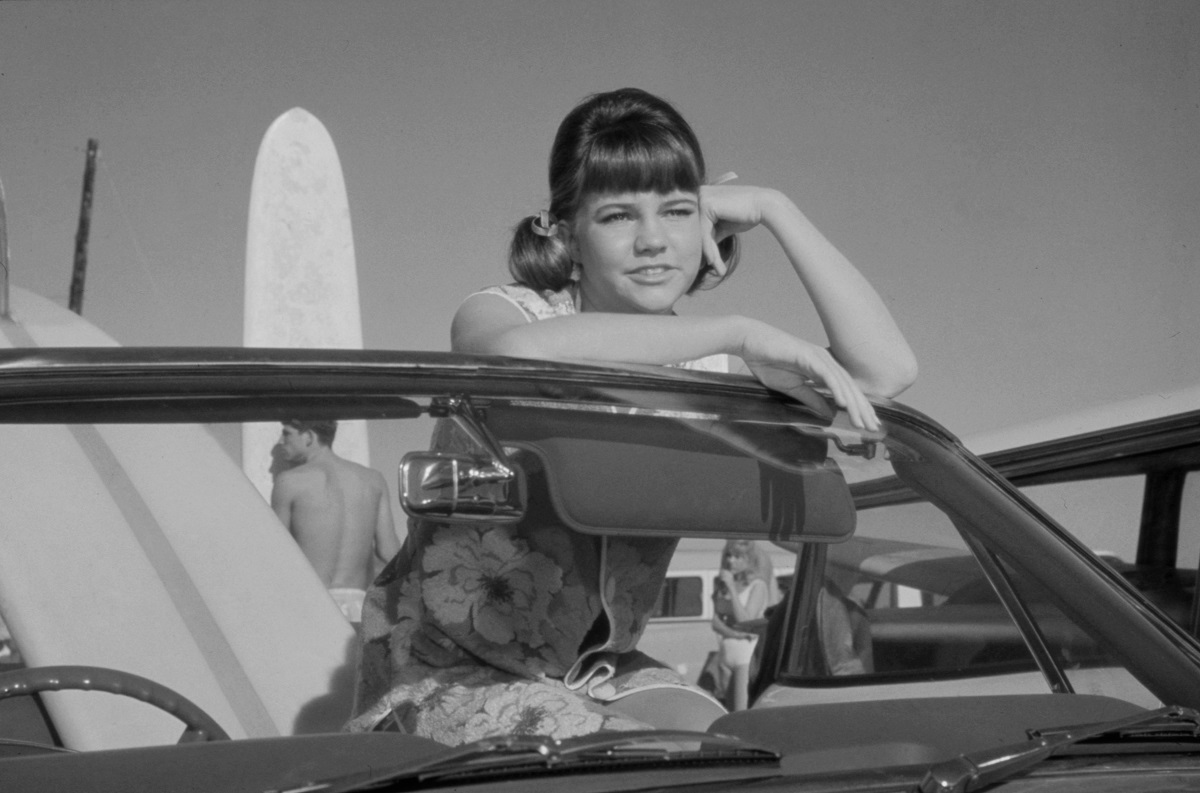 Sally Field sits in a convertible with a surf board as Gidget