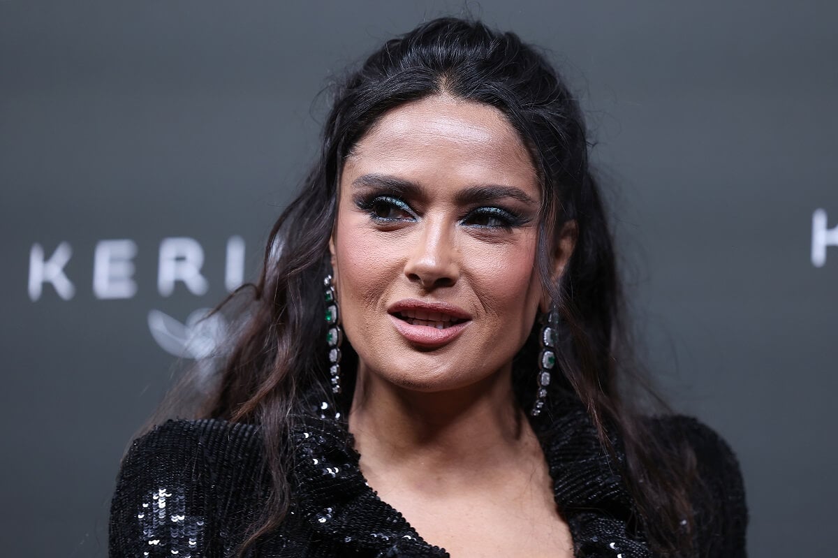 Salma Hayek taking a picture in a black dress at the 2023 Kering Women in Motion Awards.