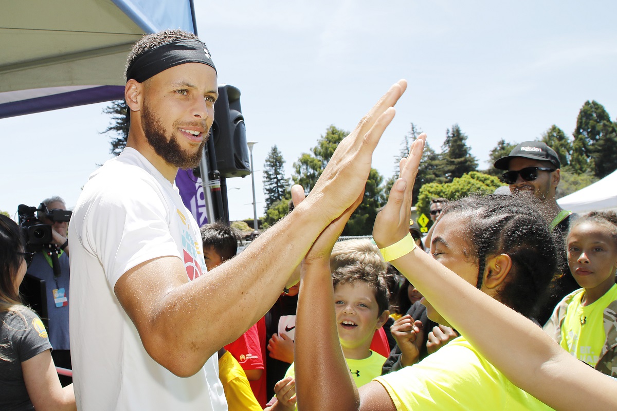 Stephen Curry greets kids at the launch of Eat. Learn. Play. Foundation