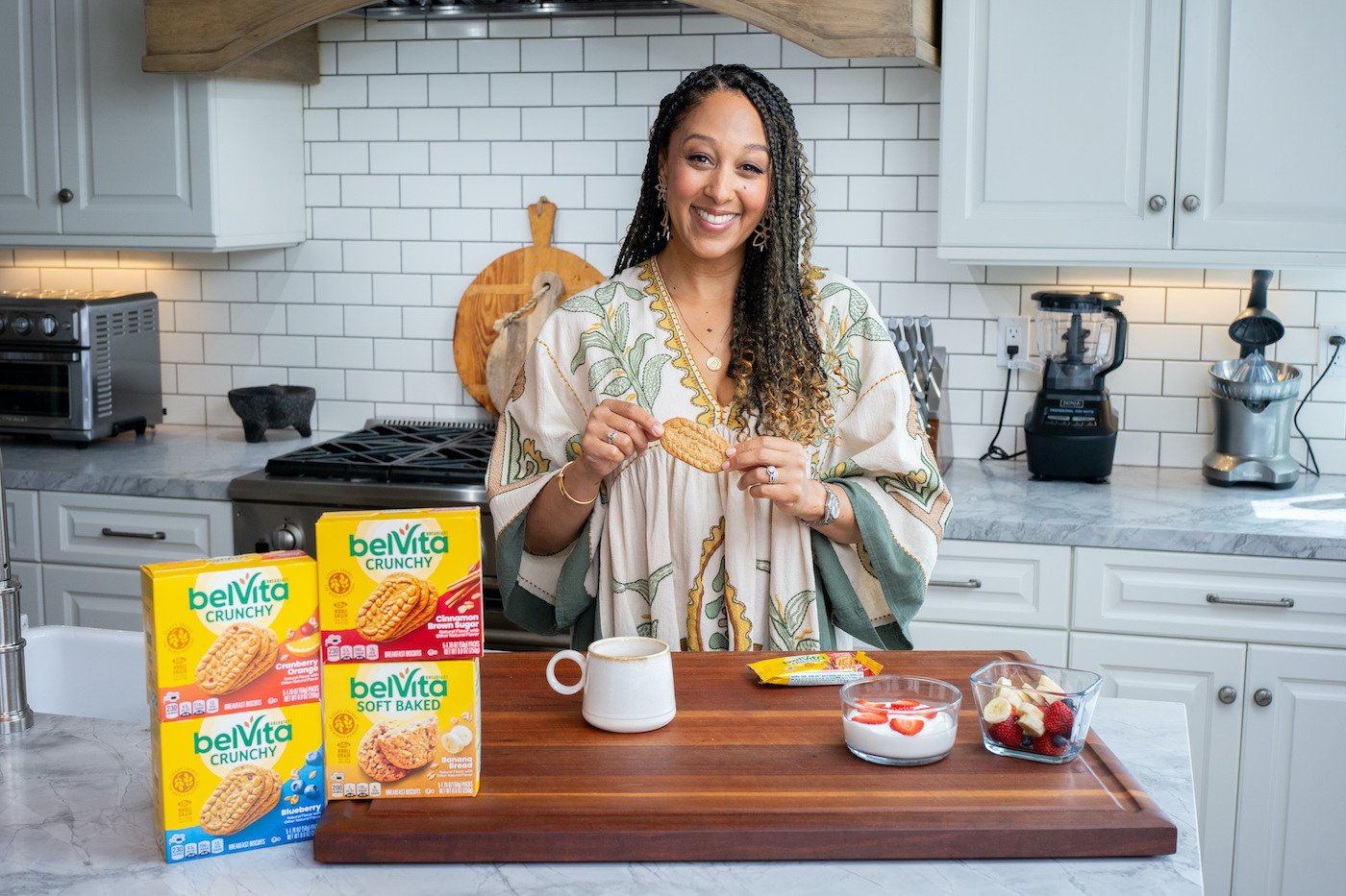 Tamera Mowry-Housley holds a belVita biscuit in her kitchen