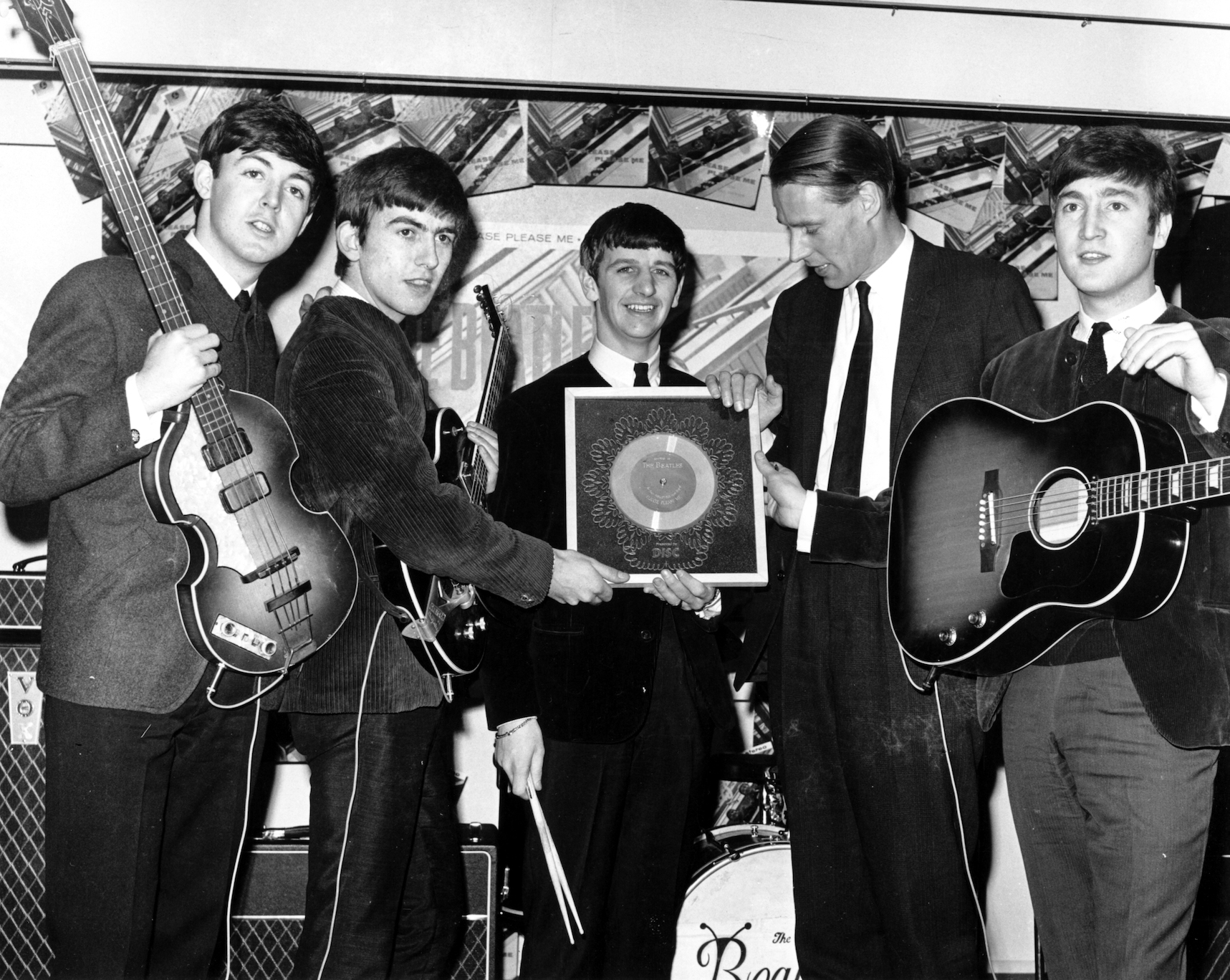 The Beatles pose for a picture with their producer George Martin