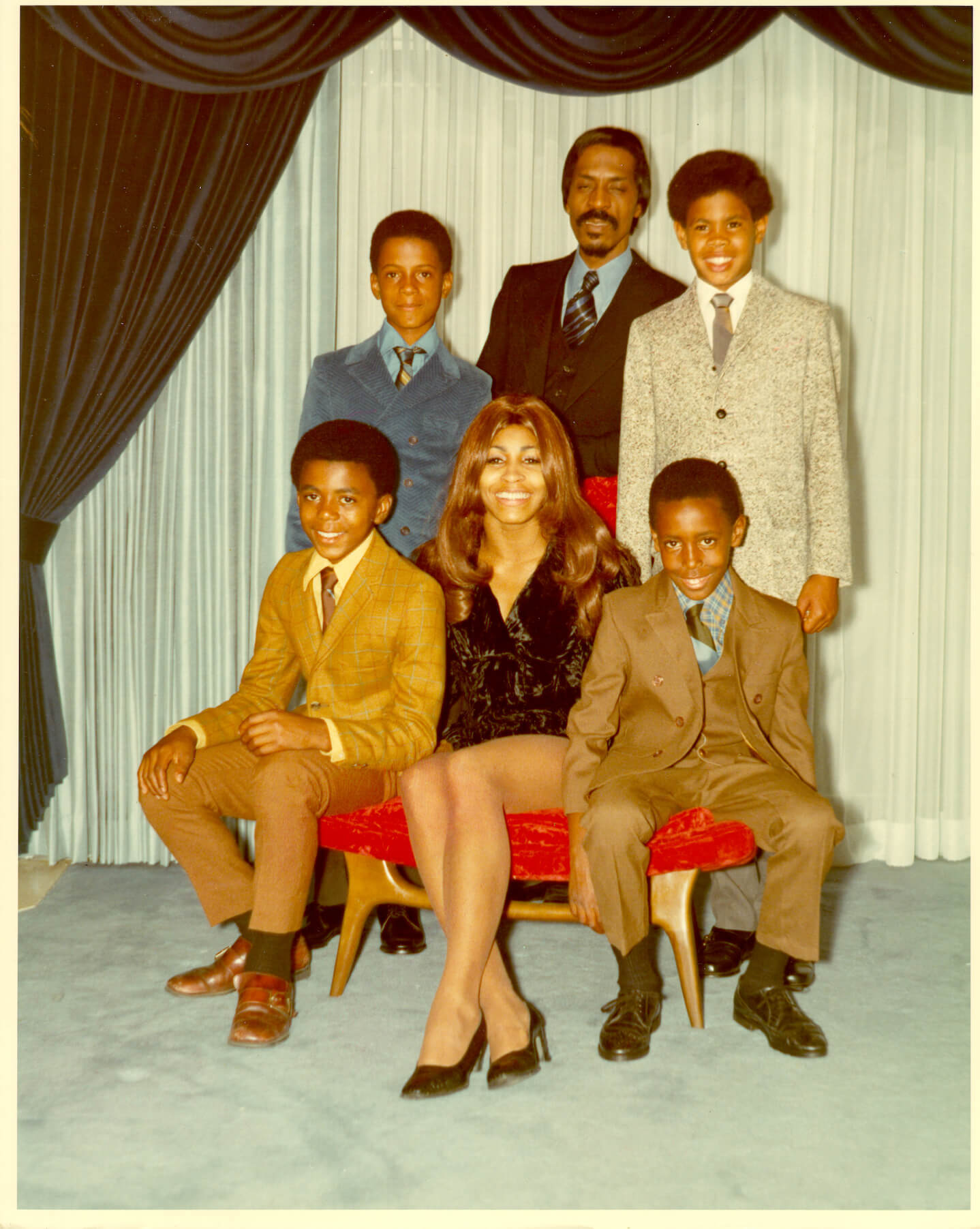 Tina Turner sitting with her kids, Michael Turner, Ike Turner, Jr., Craig Hill, and Ronnie Turner, and her husband