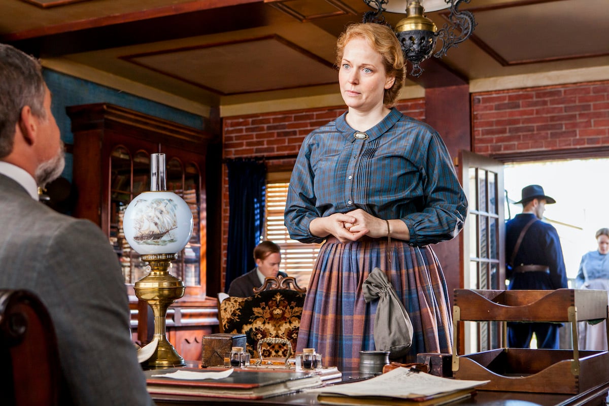 'When Calls the Heart' actor Chelah Horsdal as Cat Montgomery, standing in front of a desk