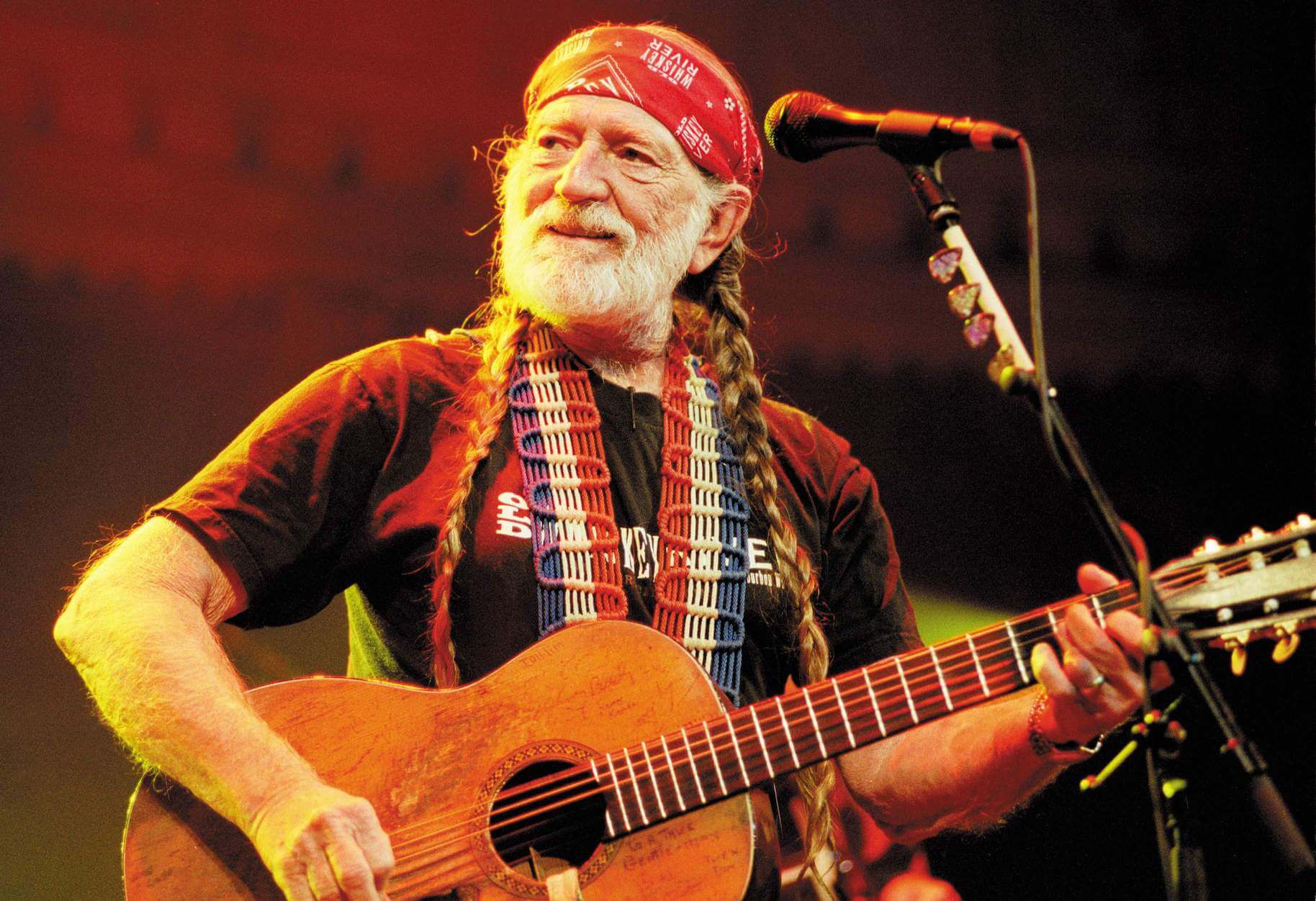 Willie Nelson on stage with a guitar