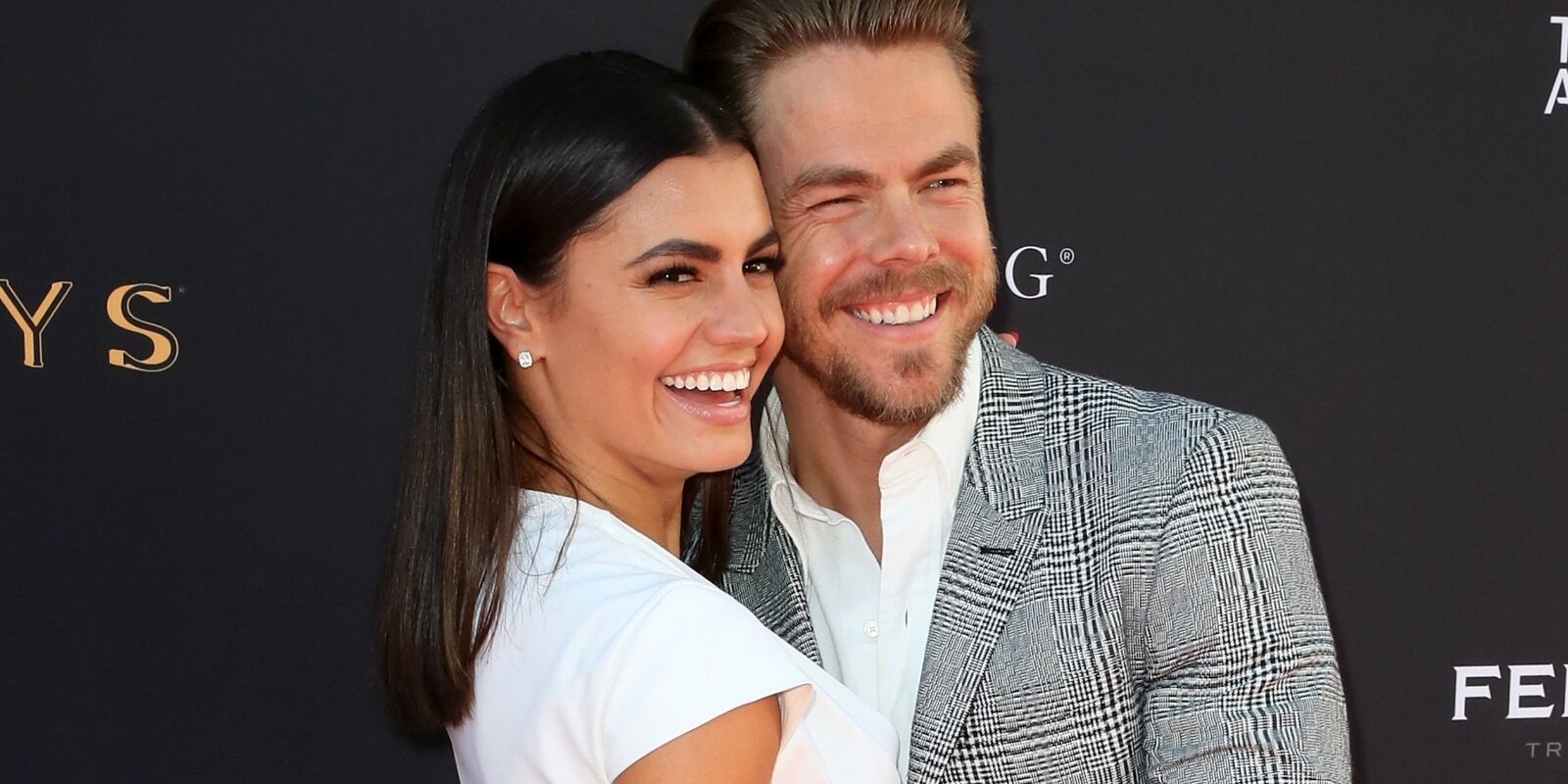 Hayley Erbert and Derek Hough smile during a red carpet event.