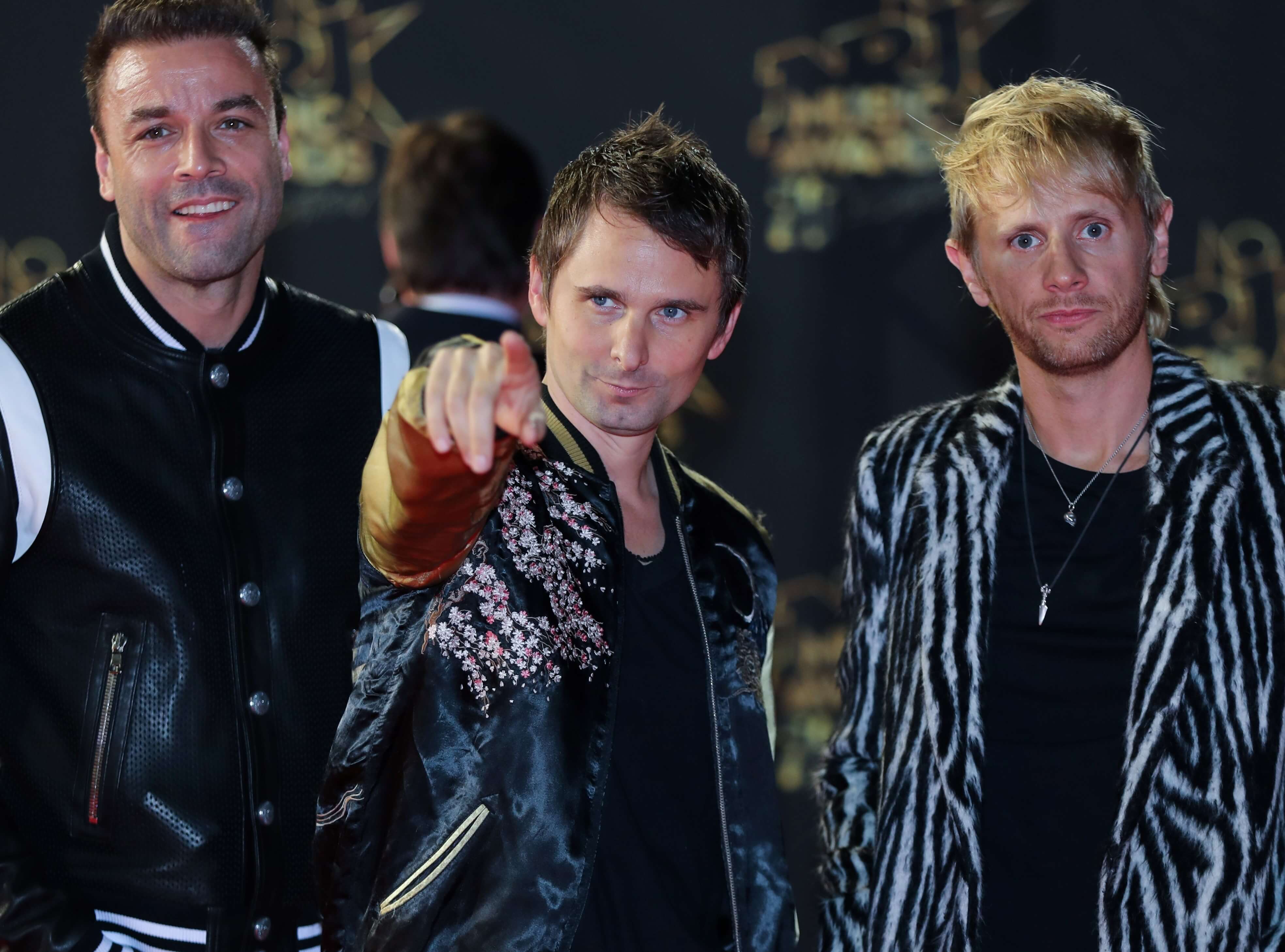 Muse members wearing jackets