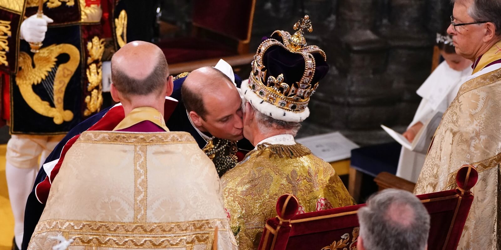 Prince William kisses King Charles on the cheek after coronation pledge.