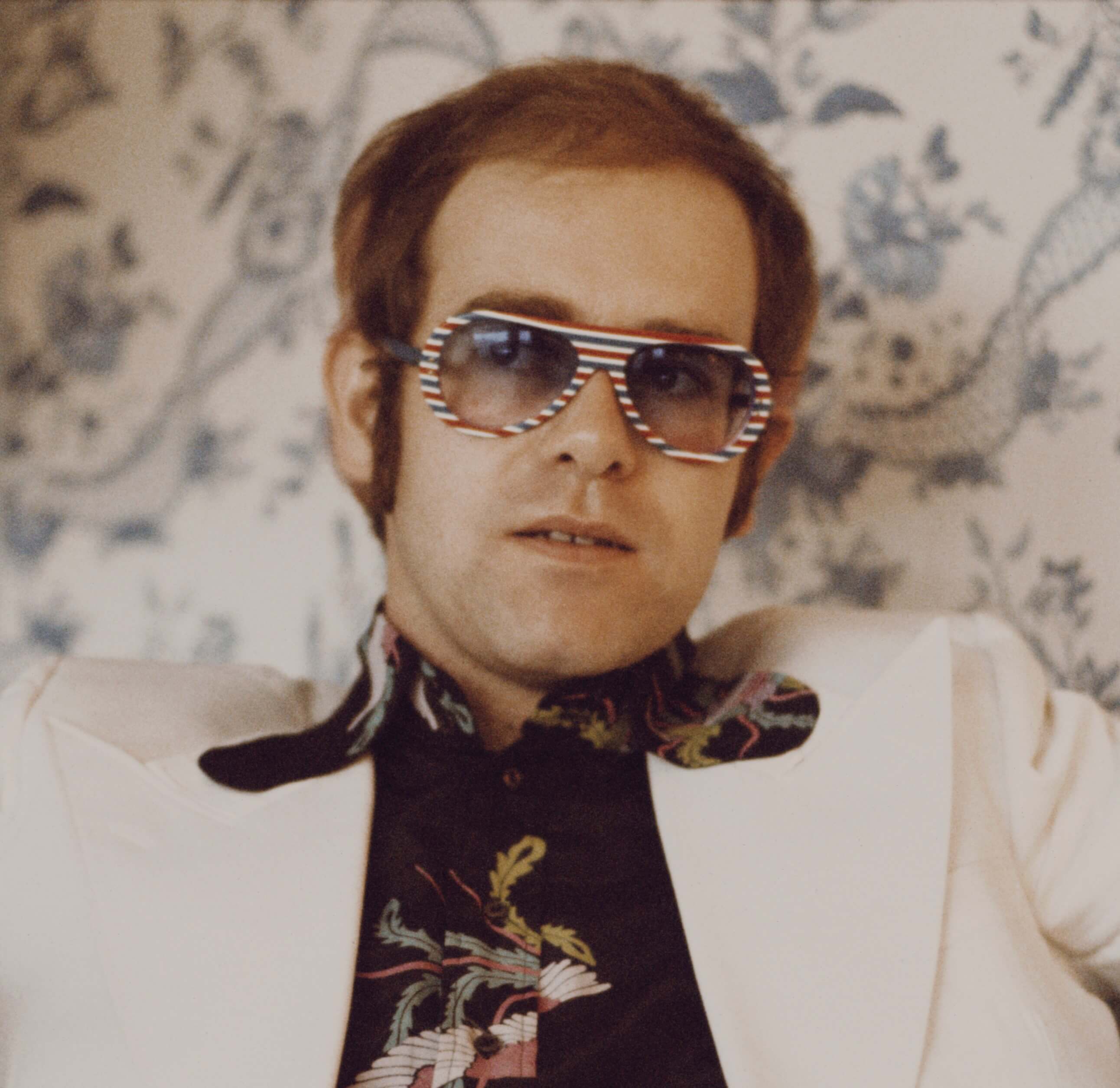 Elton John wearing a white suit