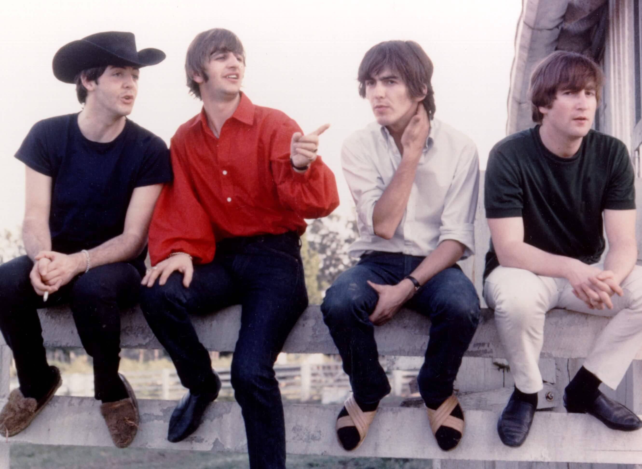 The Beatles sitting on a fence during the "Michelle" era