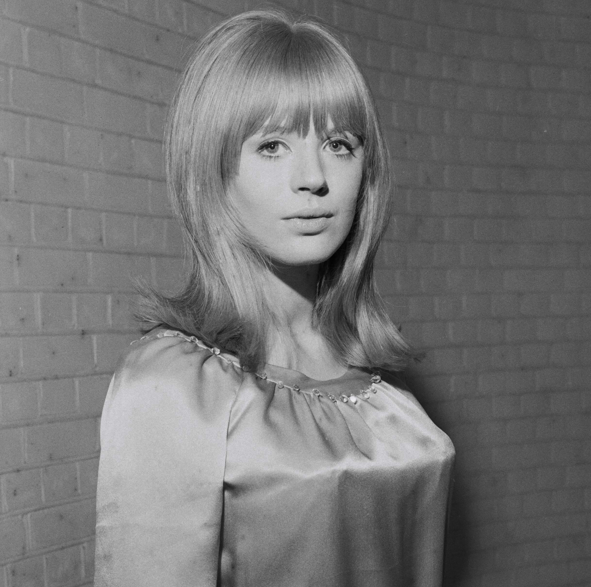 Marianne Faithfull in front of a brick wall