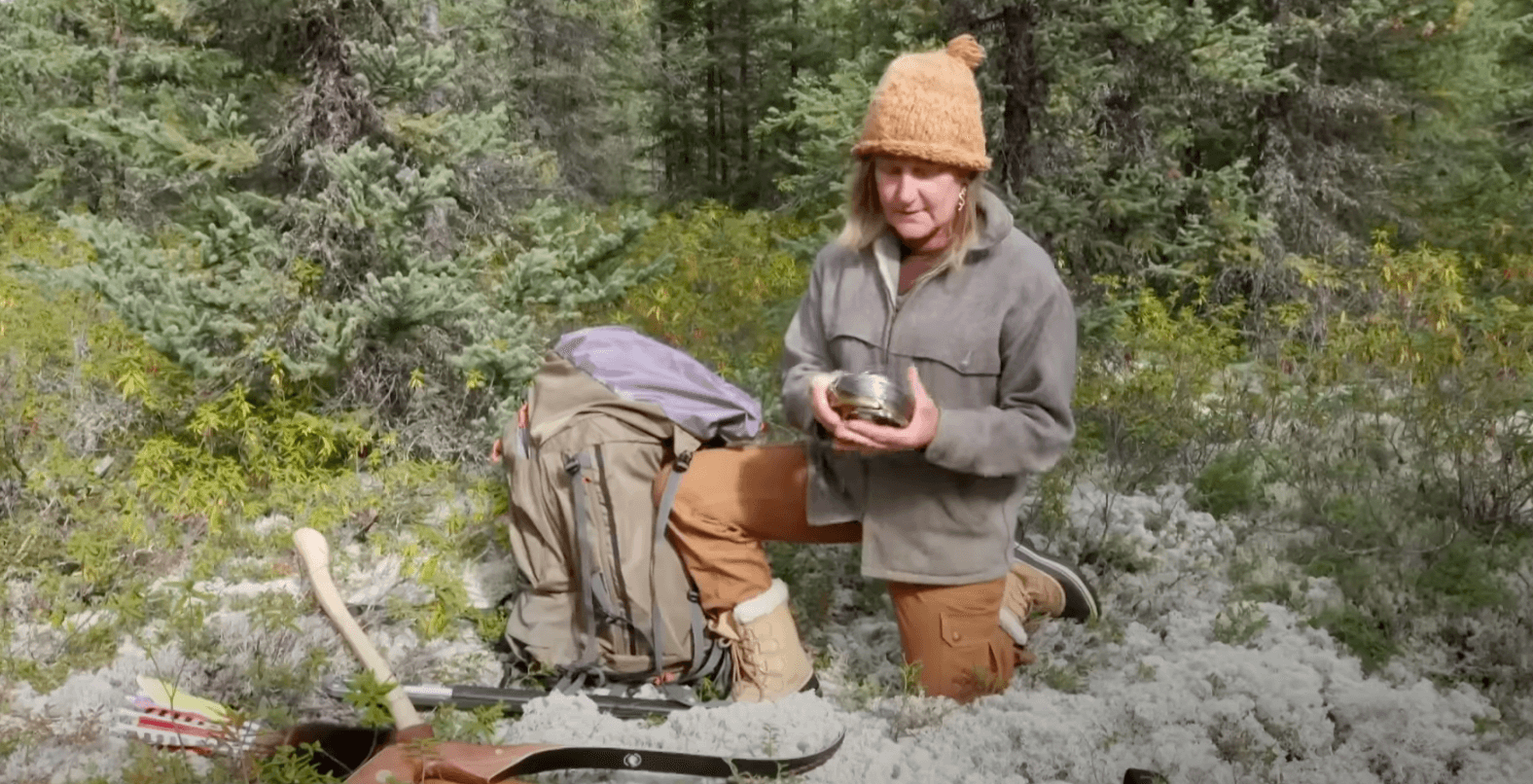 A competitor in 'Alone' on one knee holding snare wire