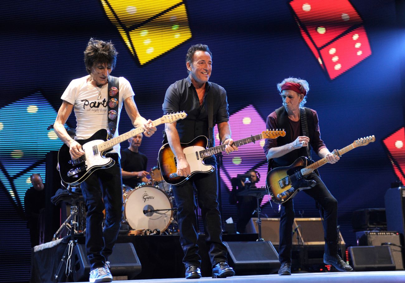 Ronnie Wood, Bruce Springsteen, and Keith Richards play guitars onstage together.