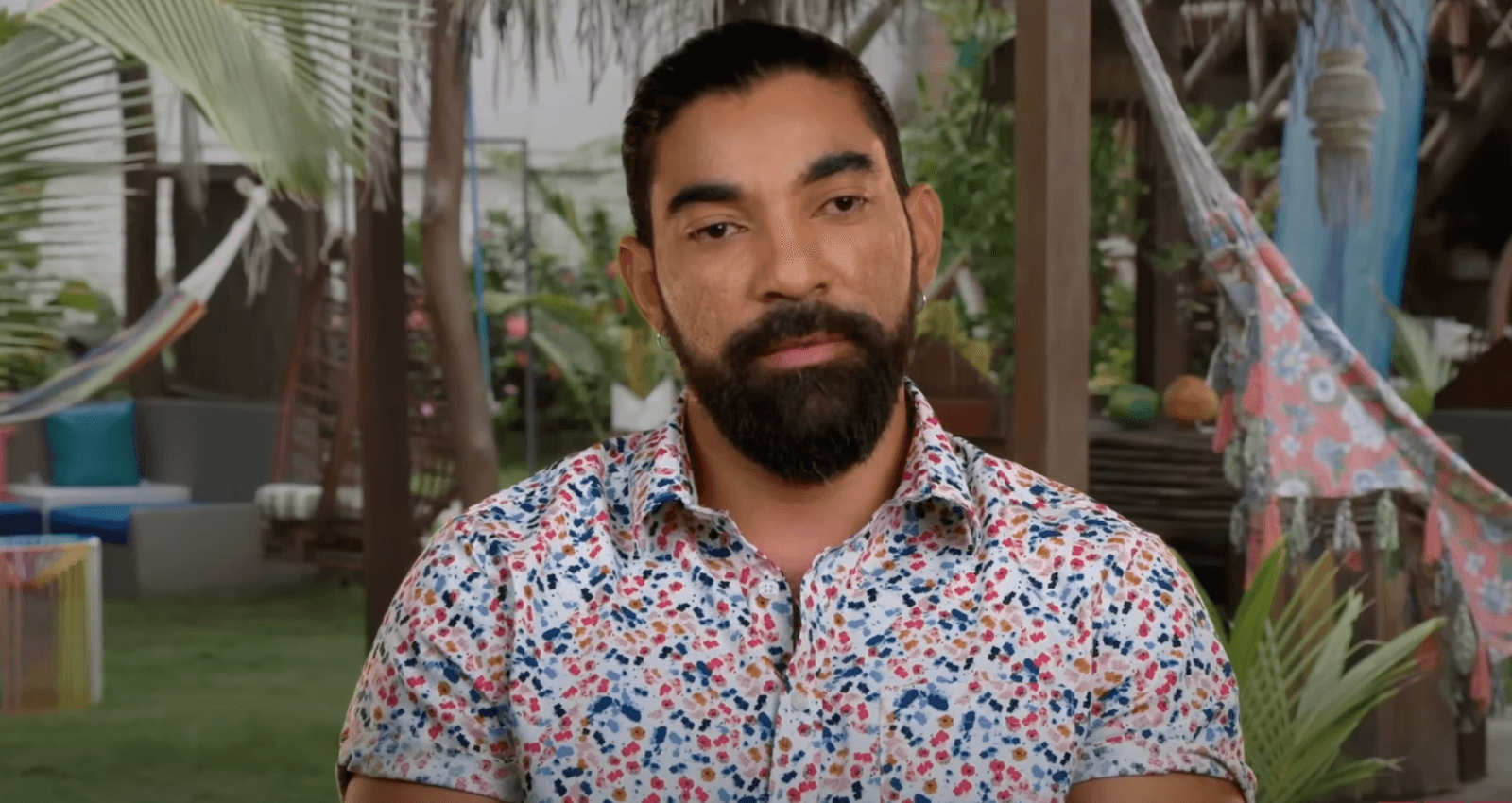 Carlos in '90 Day Fiancé: Love in Paradise' Season 3 talking against a tropical background