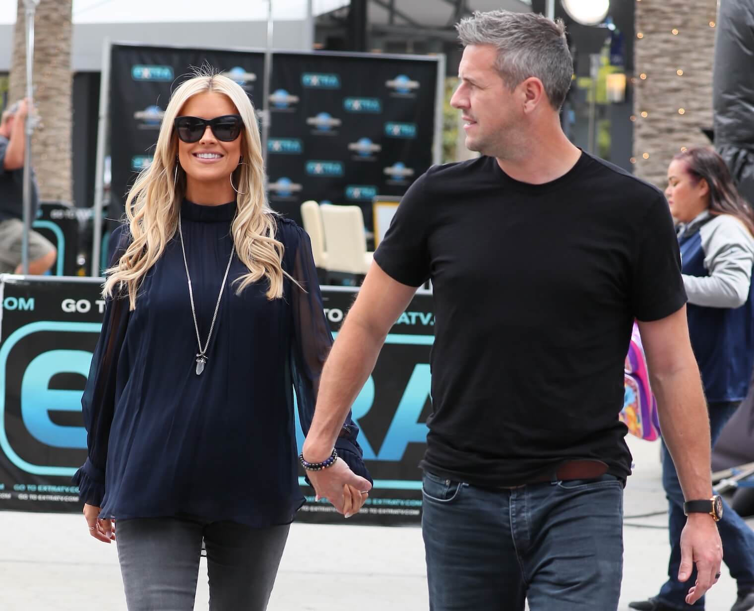 Christina Hall and her ex-husband Ant Anstead walking hand in hand outdoors