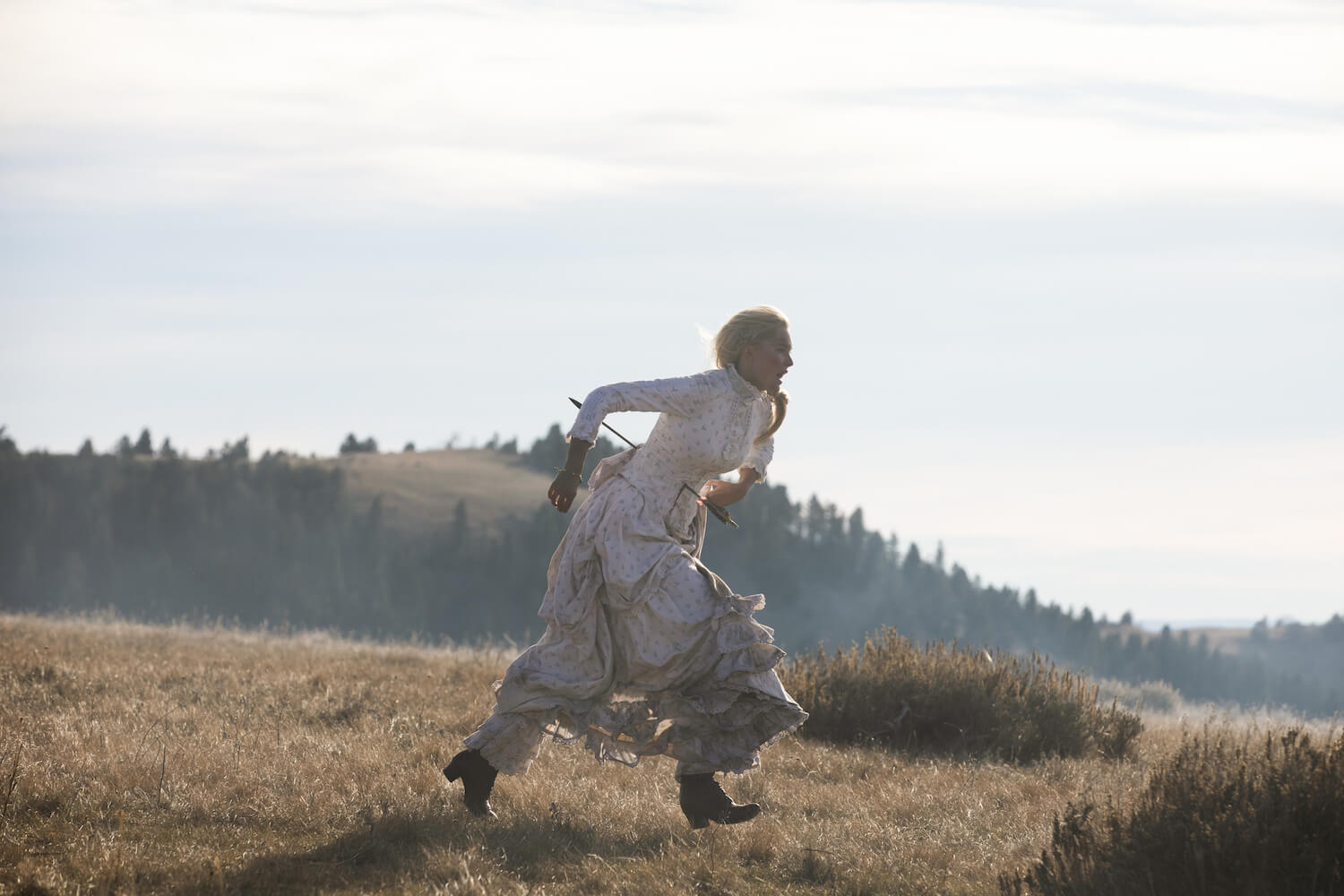 Isabel May as Elsa Dutton running with an arrow through her stomach in '1883'