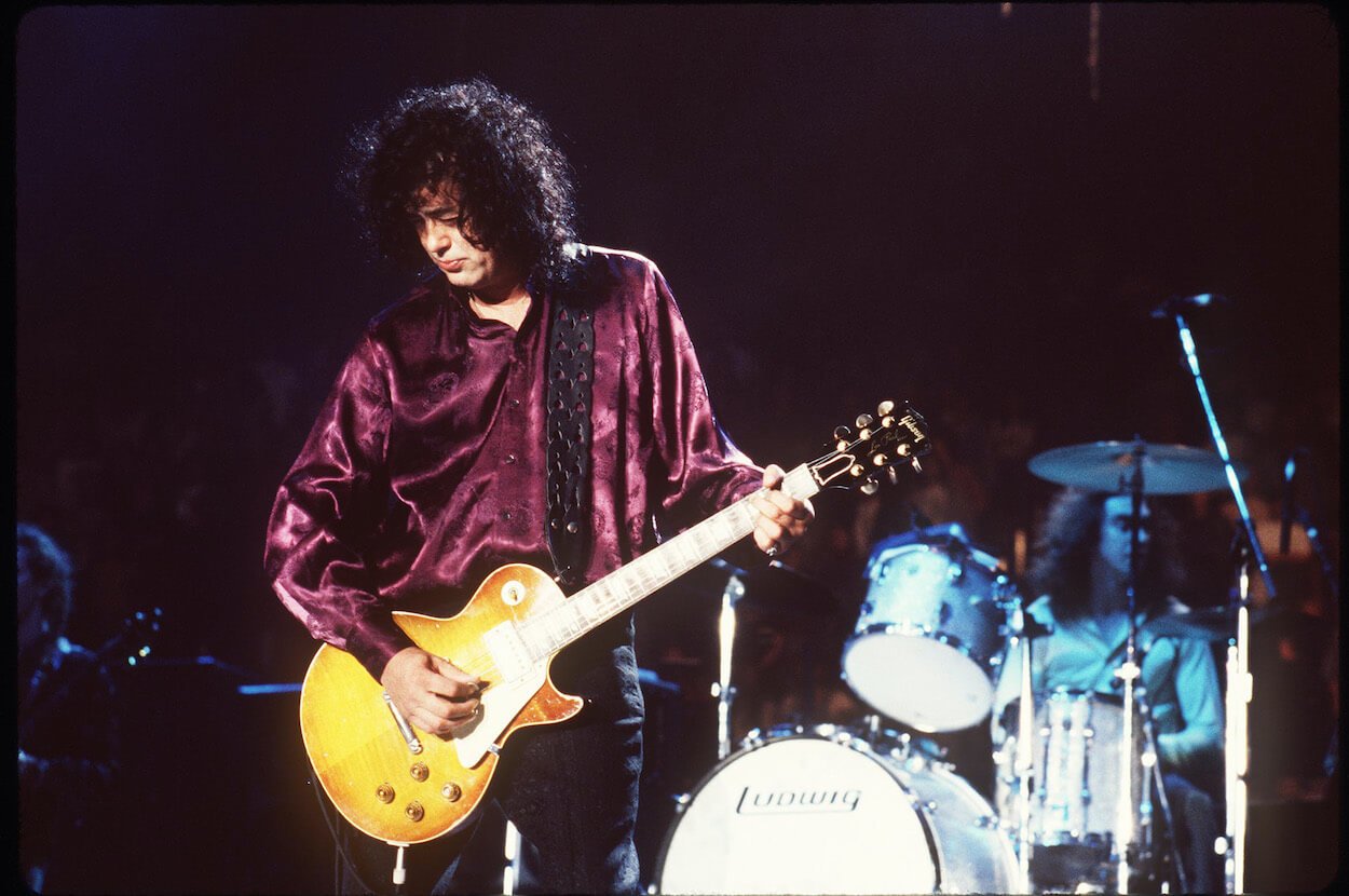 Jimmy Page playing guitar during a 1995 concert with former Led Zeppelin bandmate Robert Plant.
