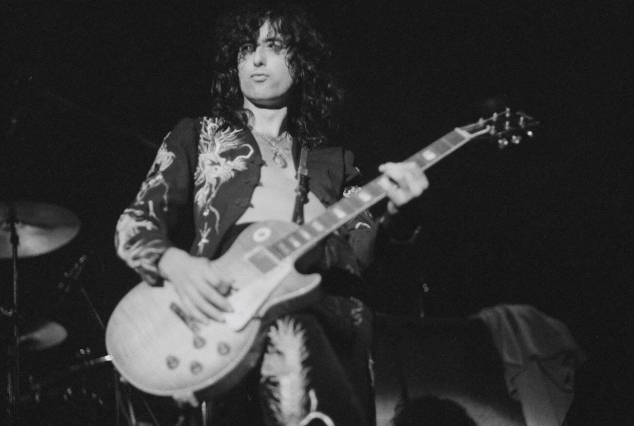A black and white picture of Led Zeppelin guitarist Jimmy Page playing guitar.