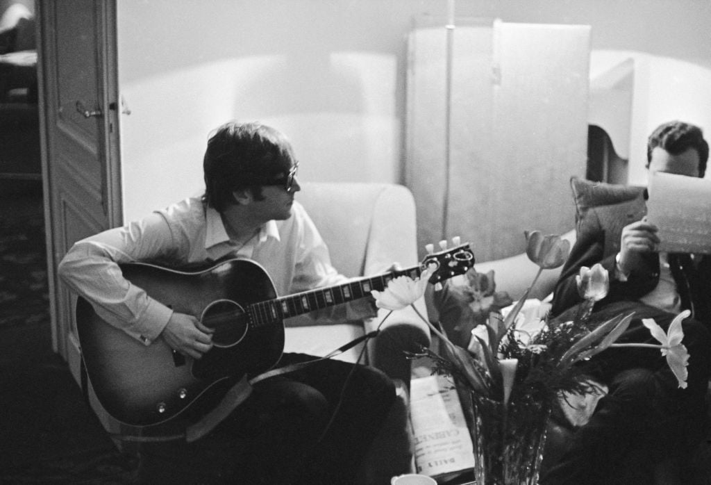 John Lennon and Brian Epstein sitting down.