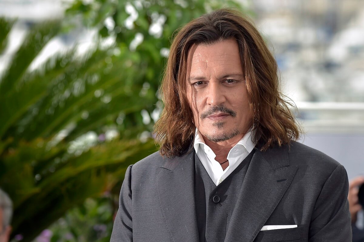 Johnny Depp taking a picture in a suit at the Jeanne du Barry Photocall.