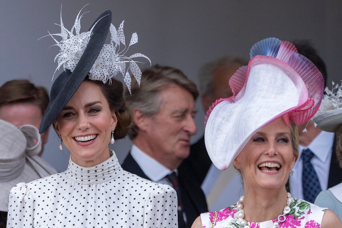 Kate Middleton and Sophie, Duchess of Edinburgh, who were likely laughing at their Prince William and Prince Edward's Order of the Garter service outfits, according to a body language expert, smile