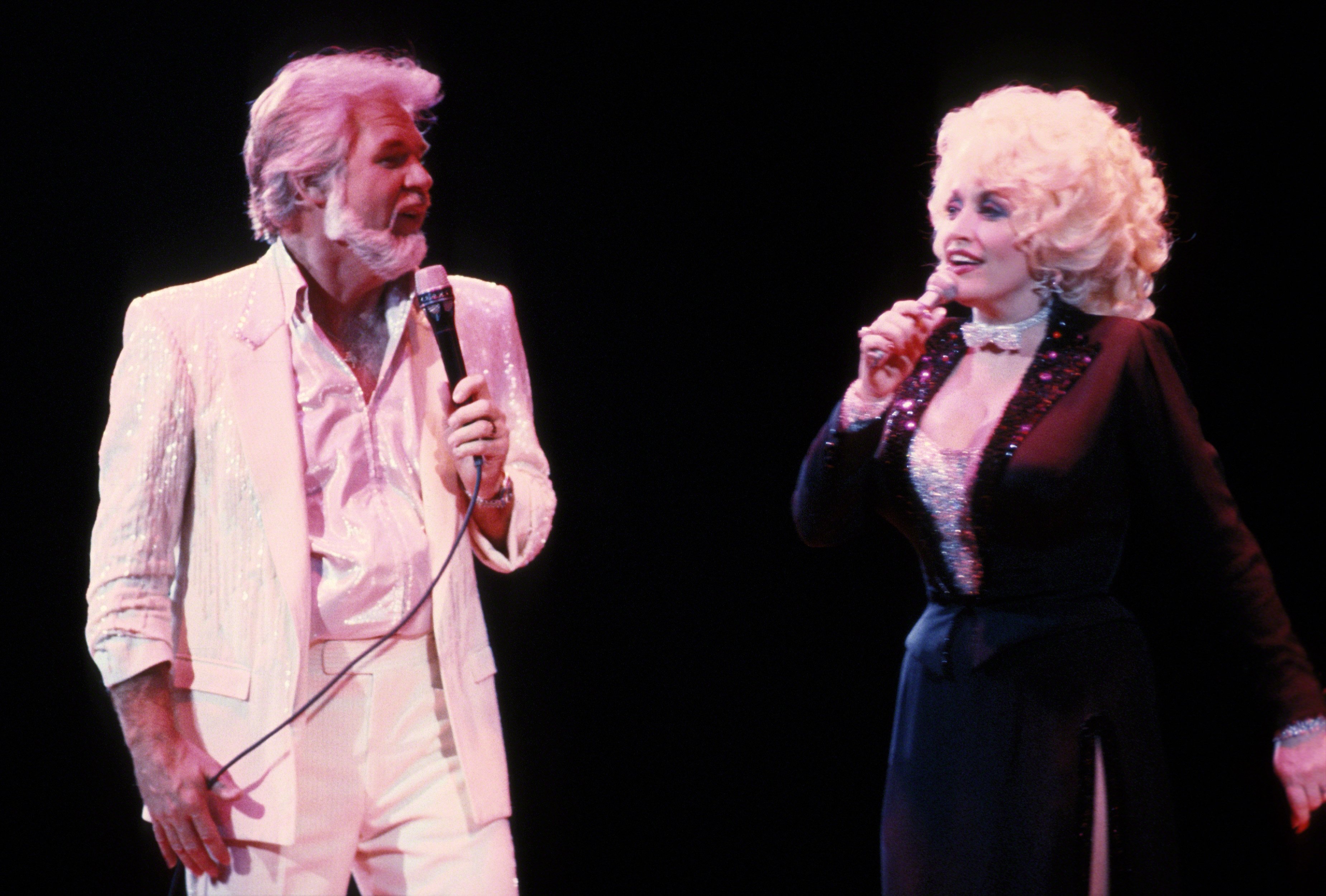 Kenny Rogers and Dolly Parton sing on stage.