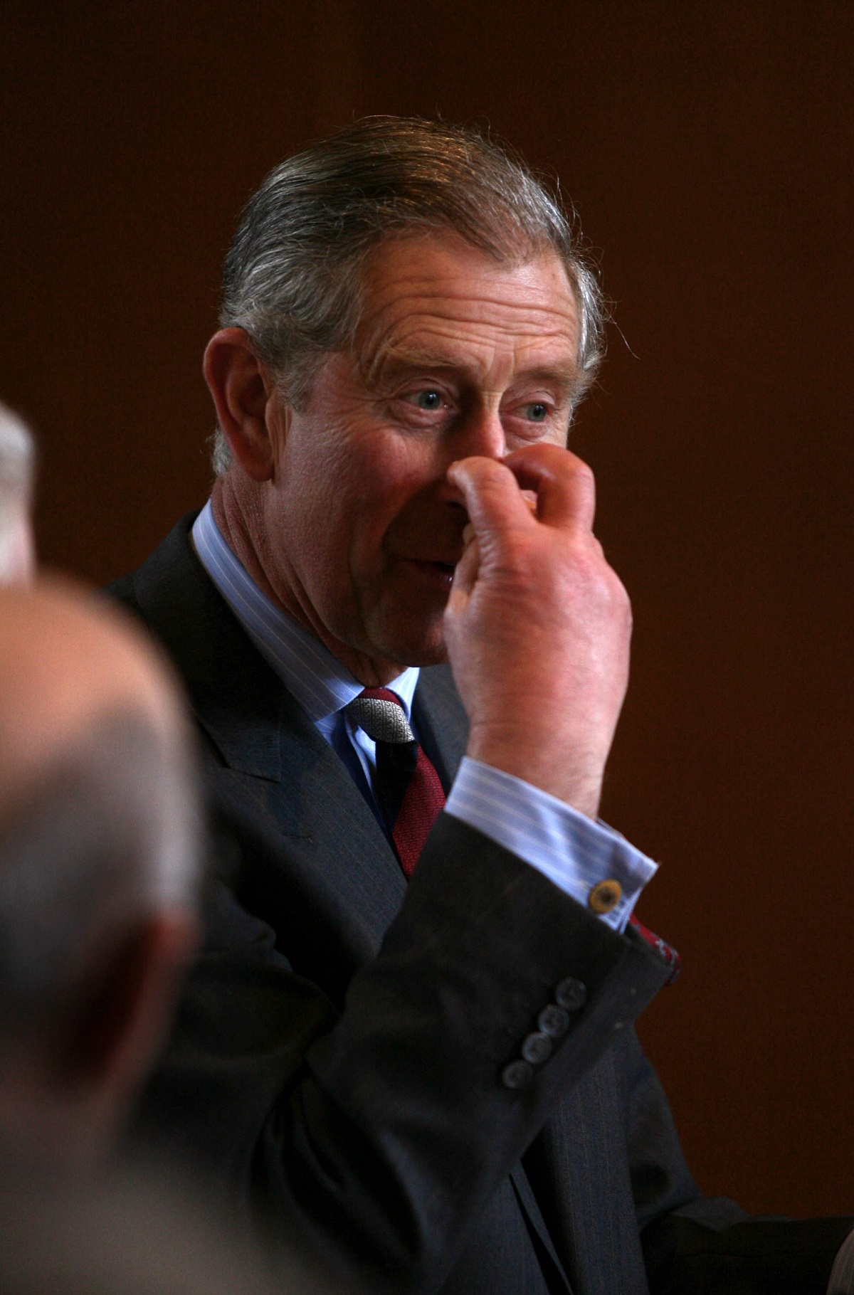 King Charles III scratching his nose with two fingers during a engagement in Walton-on-Thames, England