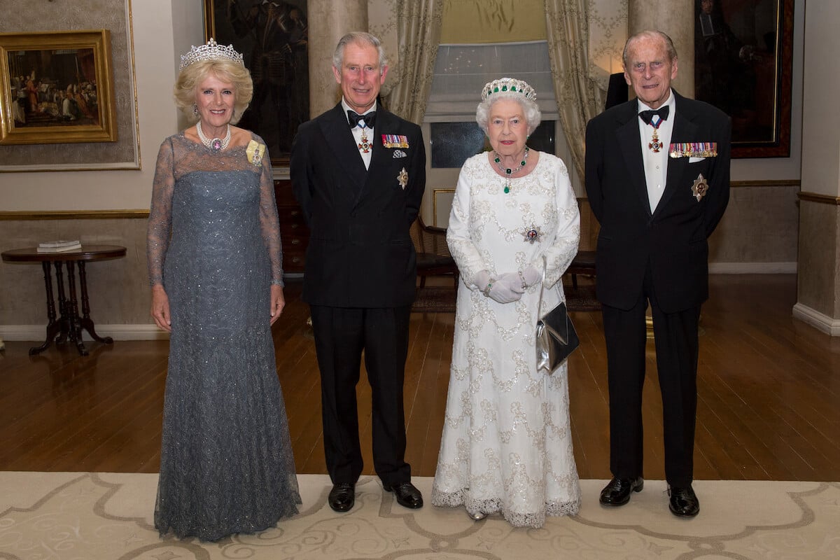 King Charles III, whose childhood drawings of Queen Elizabeth and Prince Philip are being auctioned, stands with Queen Camilla and his parents