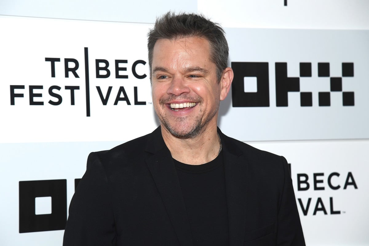 Matt Damon taking a picture while wearing a black suit at the Tribeca Festival.