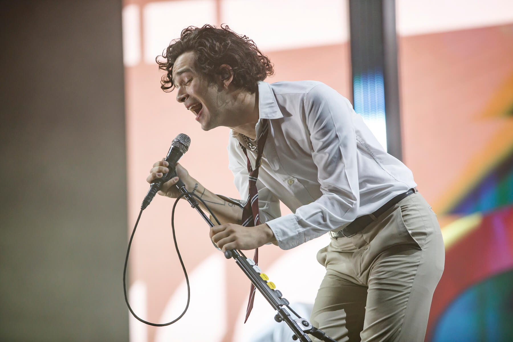 'The 1975' frontman Matty Healy singing into a microphone