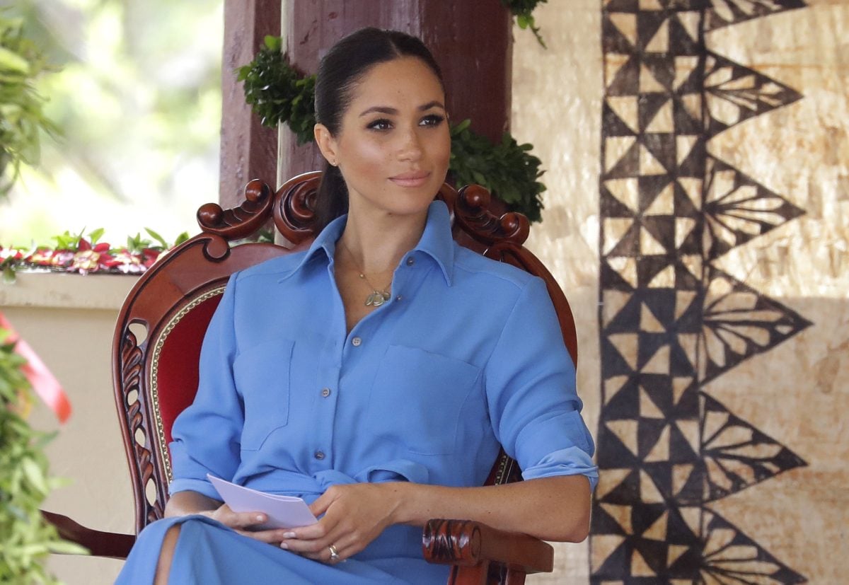 Meghan Markle, who reportedly has some royal etiquette training, talks with students during a visit to Tupou College in Tonga