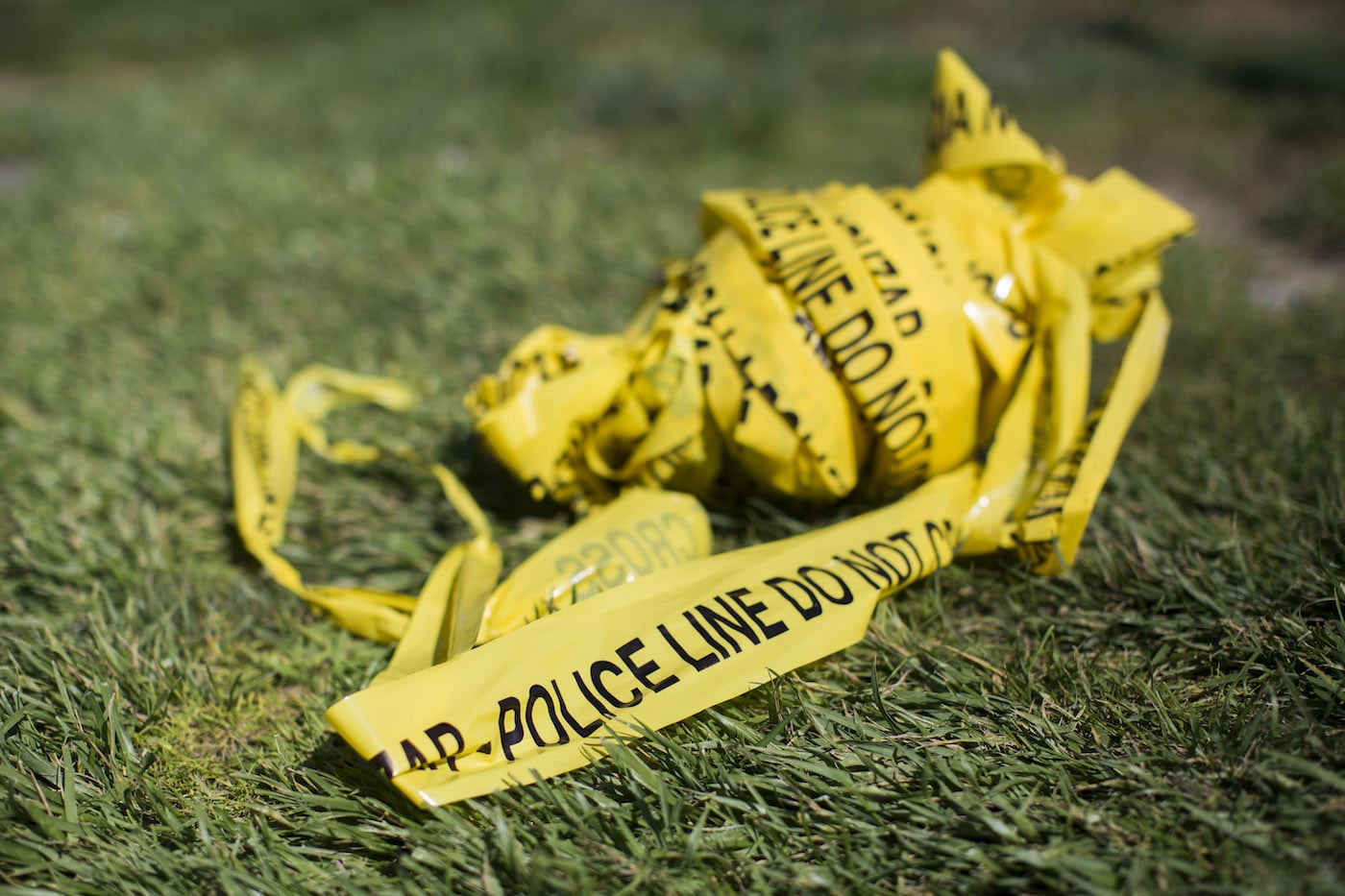 Police crime scene tape in a bundle on the grass
