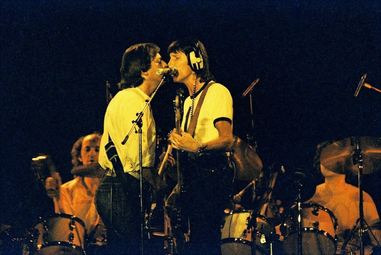 Pink Floyd's David Gilmour (left) and Roger Waters share a microphone during an August 1980 concert performance of 'The Wall.'