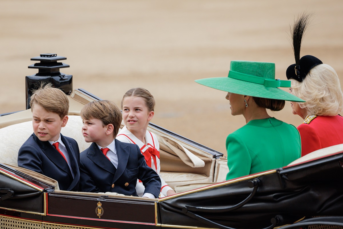 Prince George, Prince Louis, and Princess Charlotte looking back while riding in a carriage with Kate Middleton and Camilla Parker Bowles