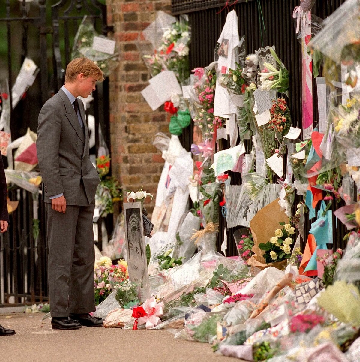 Prince William looking at floral tributes to Princess Diana outside Kensington Palace